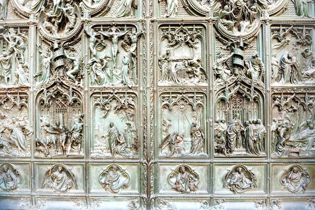 Puertas forjadas con bajorrelieves de bronce en la fachada de la catedral Duomo di Milano. Italia