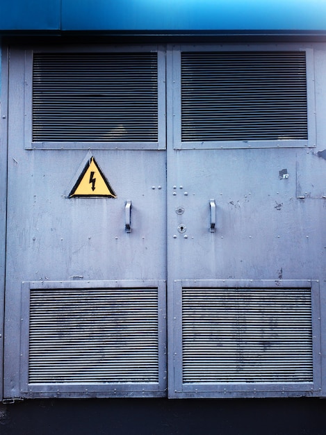 Puertas industriales cerradas al fondo de la planta de energía peligrosa