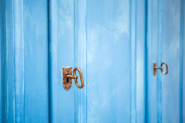 Puertas de madera de color azul claro con llaves oxidadas, textura de fondo de primer plano de diseño vintage, armario de almacenamiento retro