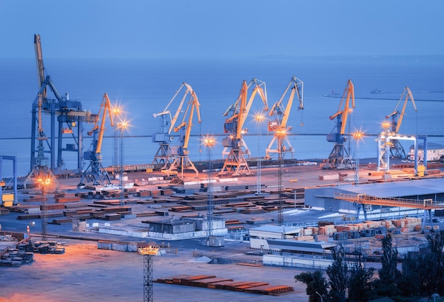 Puerto comercial marítimo por la noche en Mariupol Ucrania antes de la guerra Buque de carga de carga industrial con puente de grúas en funcionamiento en el puerto marítimo al atardecer Logística del puerto de carga Industria pesada