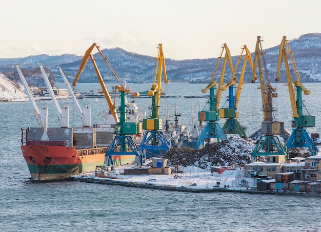 Puerto de invierno con barcos y grúas