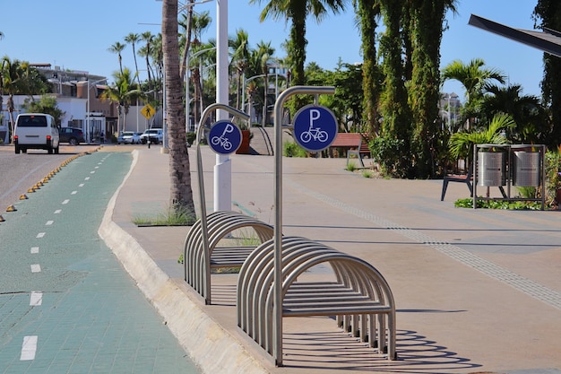 Puertos ciclistas metálicos en espacios públicos, junto a carril bici y acera.