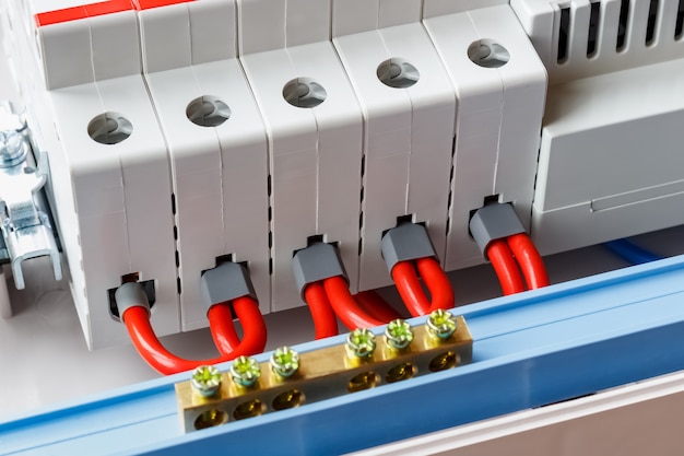 Puertos de disyuntores automáticos conectados por cables rojos closeup