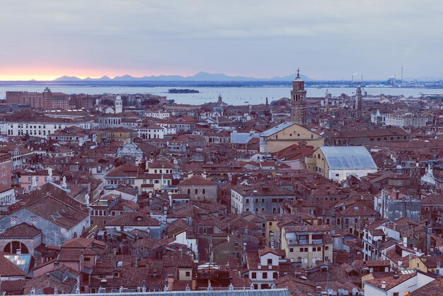 La puesta de sol aérea desde el Campanile di San Marco, vista de los techos de Venecia
