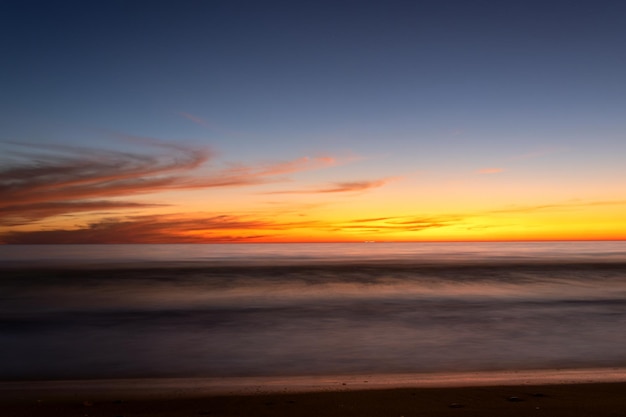 Puesta de sol amarilla en el paisaje marino de la playa para el cielo colorido de fondo hermoso reflejo del agua la luz del sol