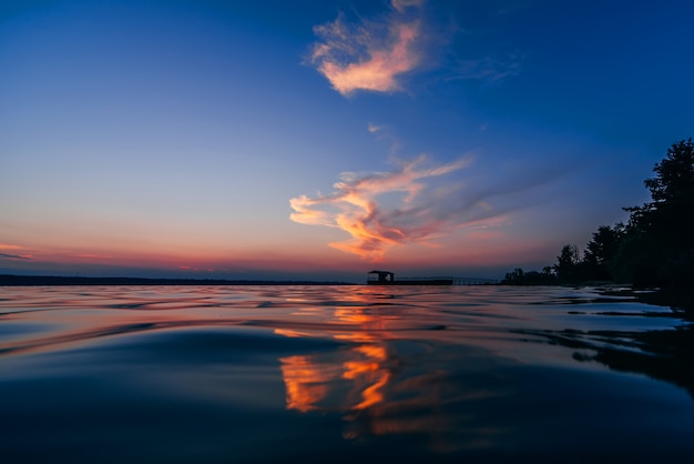 Puesta de sol azul rojo con hermoso reflejo en las olas de agua del mar