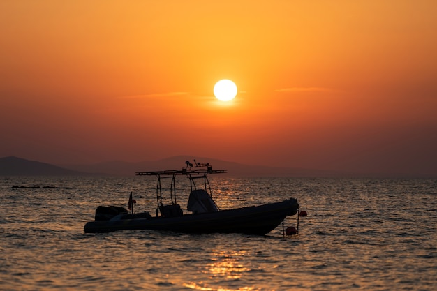 Puesta de sol brillante con gran sol amarillo la superficie del mar