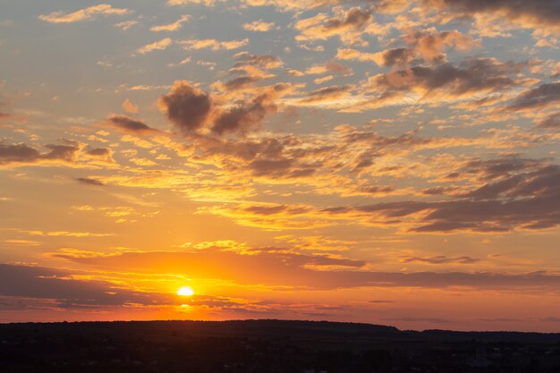 Puesta de sol cielo cubierto de nubes hinchadas de color naranja en la noche.