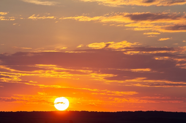 Foto puesta de sol cielo cubierto de nubes hinchadas de color naranja en la noche.