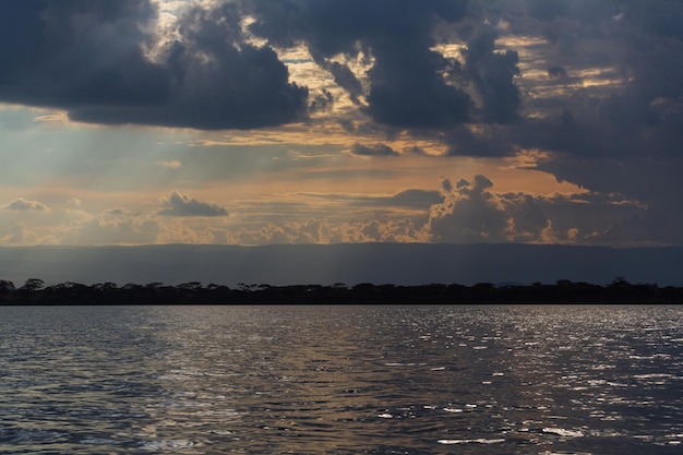 Puesta de sol con cielo naranja y nubes y agua del lago. Lago Naivasha. Kenia