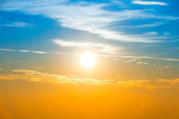 Puesta de sol en el cielo con nubes azul naranja y gran sol