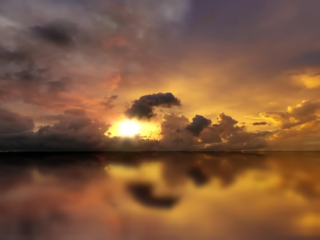 puesta de sol de cielo nublado dramático naranja en el reflejo del agua de mar en la noche sol abajo