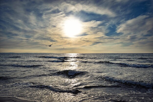 Puesta del sol y un cielo nublado pintorescamente dramático sobre el mar tempestuoso