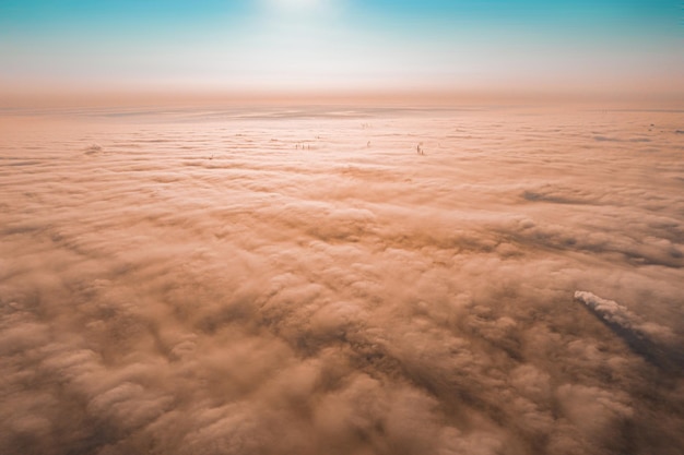 Puesta de sol cielo nublado desde vista aérea. Vista de avión por encima de las nubes. Nubes polvorientas sobre la ciudad. Polvo. Polución. Playa. Huracán de arena. Peligroso. Hogar