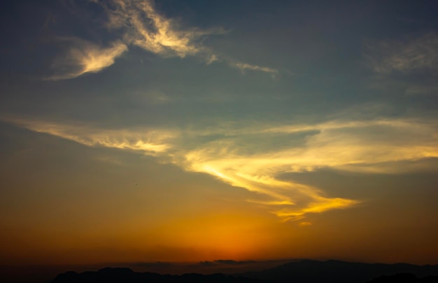 Puesta de sol de cielo rojo en las montañas Nube con forma de S como un superhombre