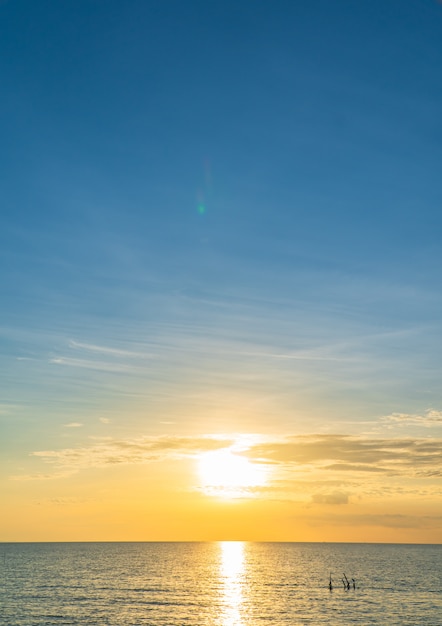 Puesta de sol cielo sobre mar vertical en la noche con luz solar colorida naranja