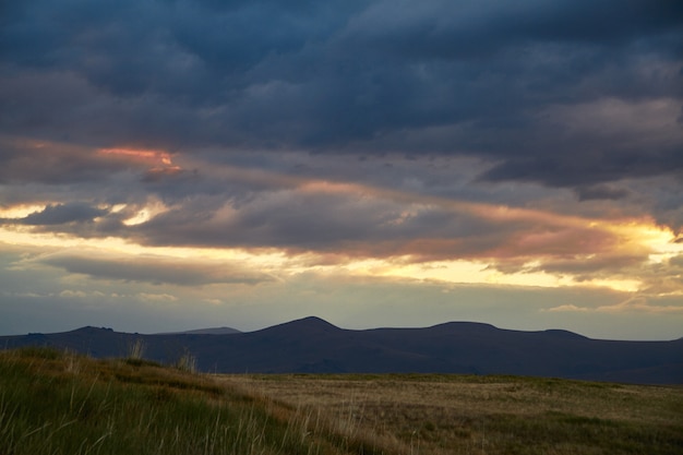 Puesta de sol en el desierto, los rayos del sol Brillan a través de las nubes. Meseta De Ukok De Altai