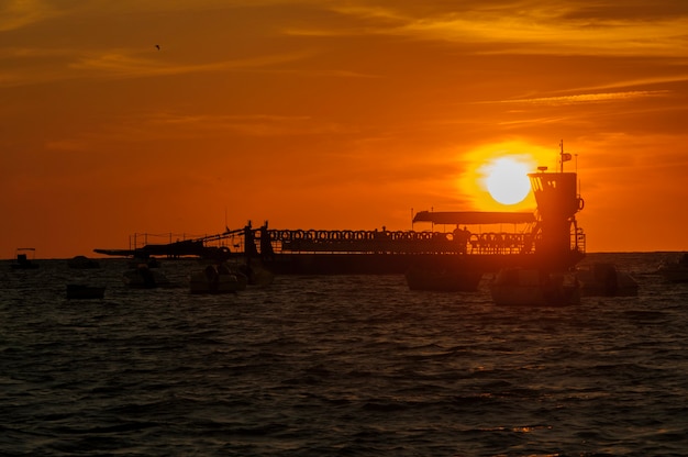 Puesta de sol detrás de los barcos de pesca del río.