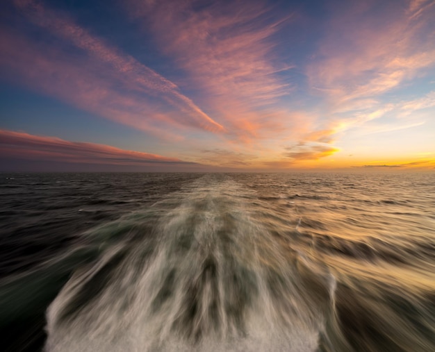 Puesta de sol detrás de un crucero de crucero en el mar