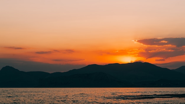 Puesta de sol dorada en la costa del mar de montaña