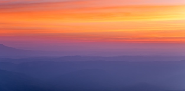 Puesta del sol dramática y salida del sol sobre la mañana de la montaña que iguala el cielo crepuscular.