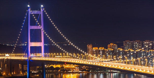 Puesta del sol e iluminación ligera del puente colgante de la señal del puente de Tsing ma en el área de Tsing yi de Hong Kong China.