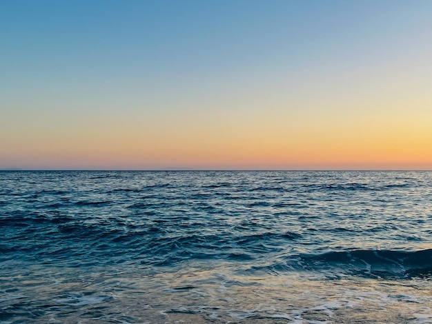 Puesta de sol escénica sobre el mar Jónico en Vlore Albania Hermosas aguas ondulantes con olas tranquilas