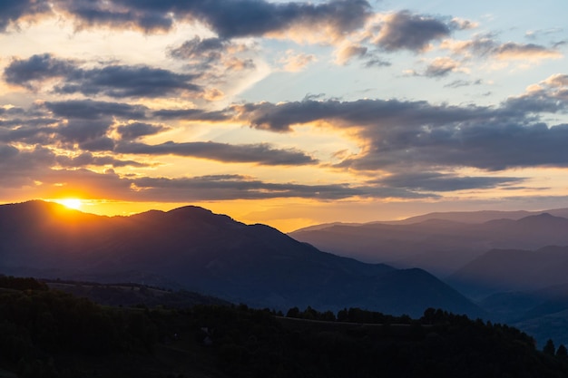 Puesta de sol escénica sobre el paisaje de montañas y colinas.