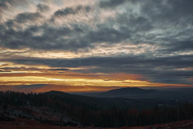 La puesta de sol con un espectacular cielo nublado sobre las montañas forma un hermoso paisaje natural