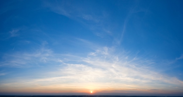 Puesta de sol espectacular, los rayos del sol brillan a través de las nubes.