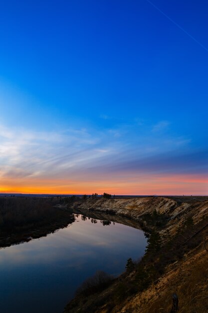 Puesta de sol en el fondo de la suave superficie del río.