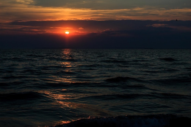 Puesta del sol en el horizonte de la tarde de la playa del mar