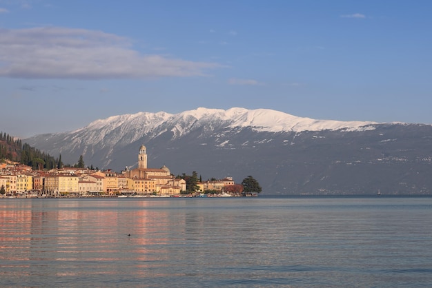 Puesta de sol de invierno en el paseo marítimo de la ciudad de Salo en el lago de Garda frente a las montañas alpinas