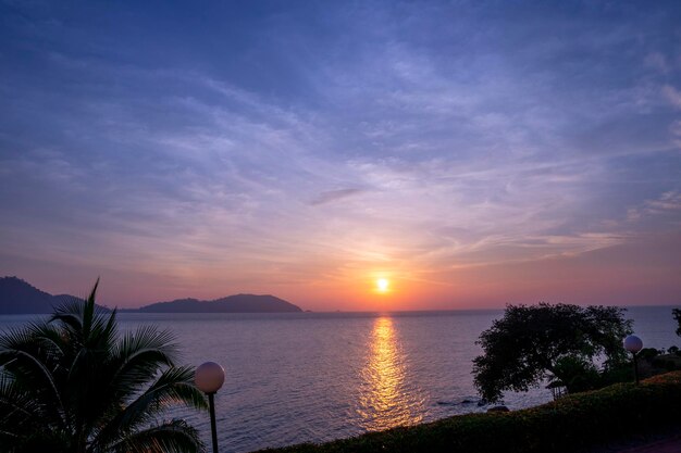 Puesta de sol junto al mar con palmeras Fondo de vacaciones de verano