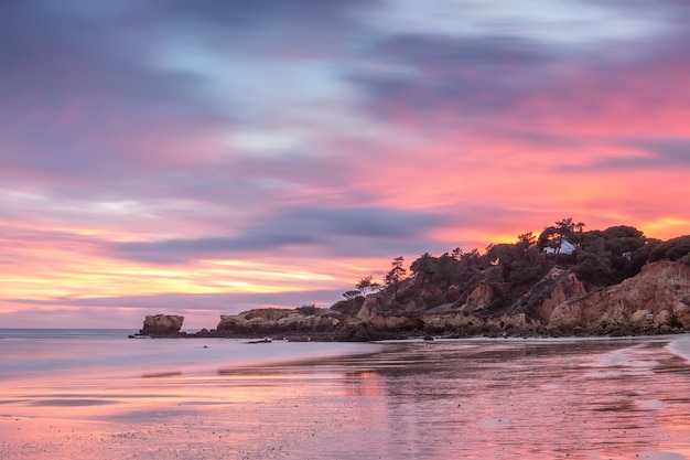 Puesta del sol mágica roja en la playa de Oura en Albufeira. Portugal