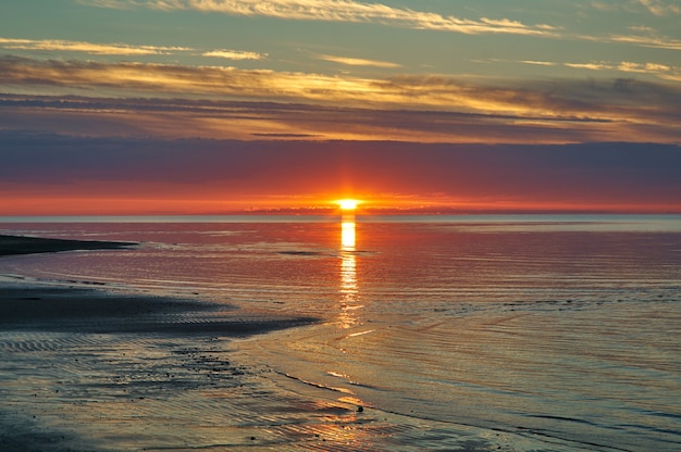 Puesta de sol del mar blanco, rusia costa arenosa de la costa sur