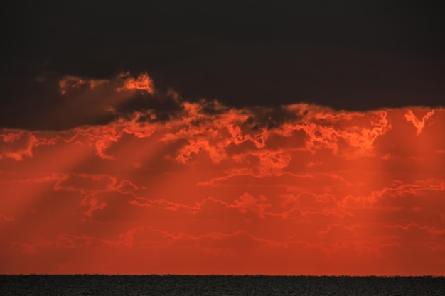 Puesta de sol en el mar con nubes dramáticas.