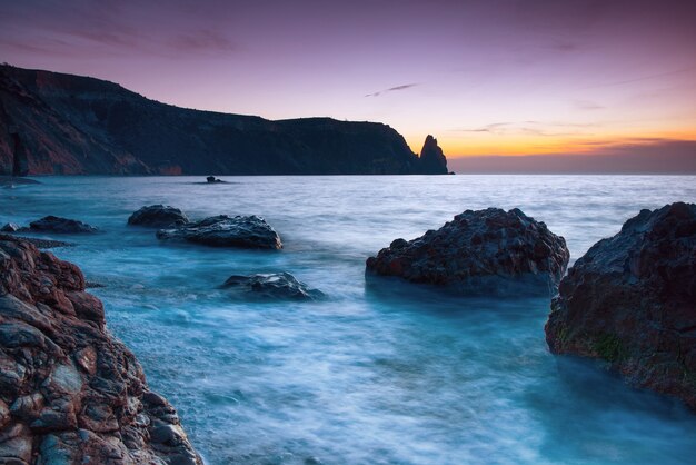 Puesta de sol de mar en la playa con rocas y cielo espectacular