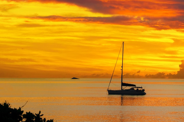 Puesta de sol en el mar y la silueta del yate de vela