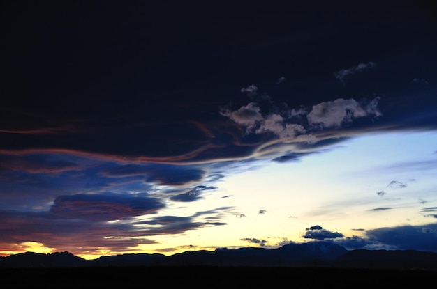 Puesta de sol con montañas y nubes negras