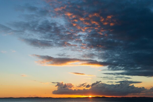 La puesta de sol naranja grandes nubes oscuras