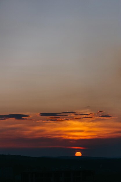 Foto puesta de sol naranja con pocas nubes