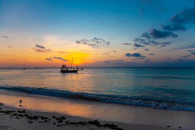 Puesta de sol naranja tropical con nubes y cielo azul