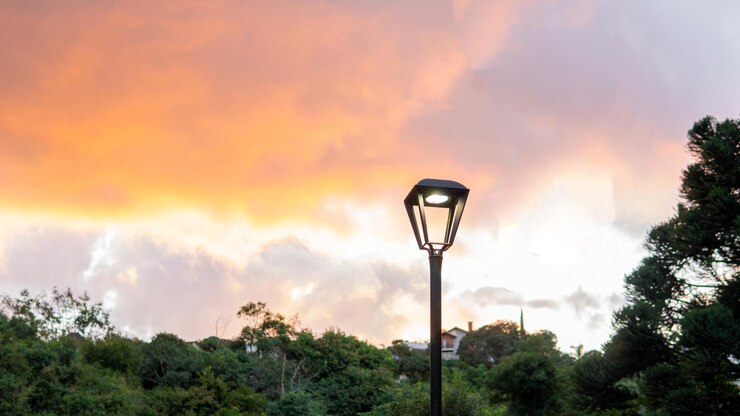 puesta de sol con nubes naranjas con un poste de luz con espacio de copia
