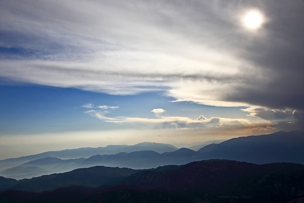 Puesta de sol en las nubes sobre un fondo de montaña