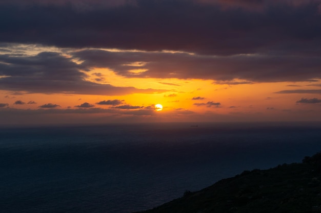 Puesta del sol nublada en el acantilado Malta