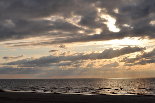 Puesta de sol nublada sobre el mar Báltico. Parece rayos del cielo.