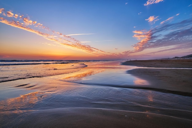 Puesta de sol en el océano atlántico con olas en la playa de fonte da telha portugal