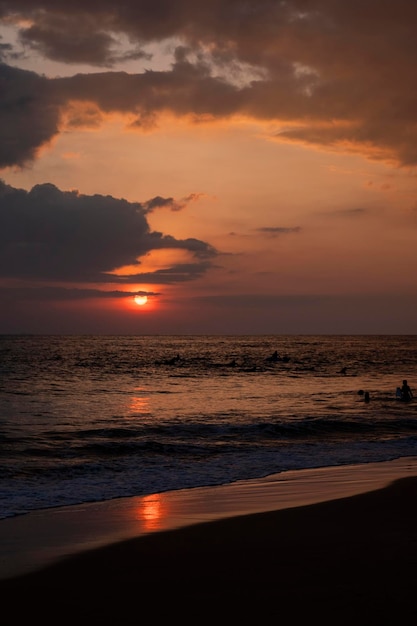 Puesta de sol en el océano con surfistas en sri lanka