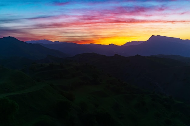 Puesta de sol en el paisaje de la tarde de las montañas con cielo brillante